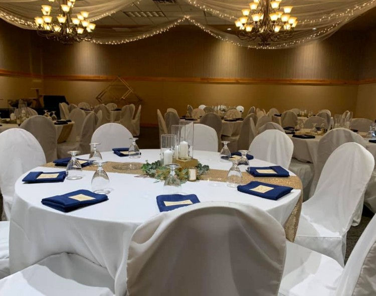 venue space with round tables with white cloths and place settings