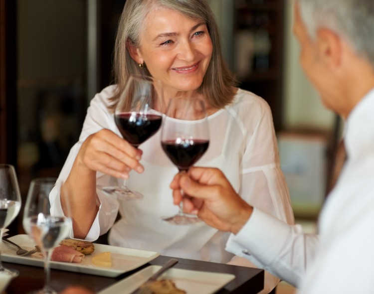 man and woman enjoying intimate dinner with glasses of wine