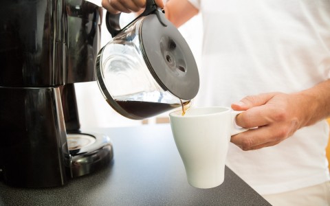 person pouring coffee into mug
