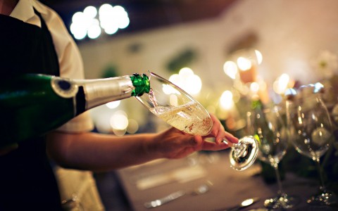 waiter filing a glass of champagne up