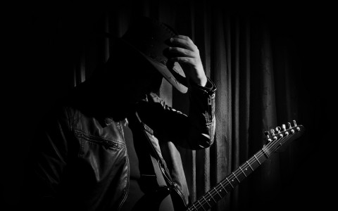 Black and white image of a musician with his guitar 