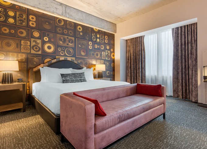 Sophisticated hotel room during the night with features as a comfy couch, two nightstands and lamps