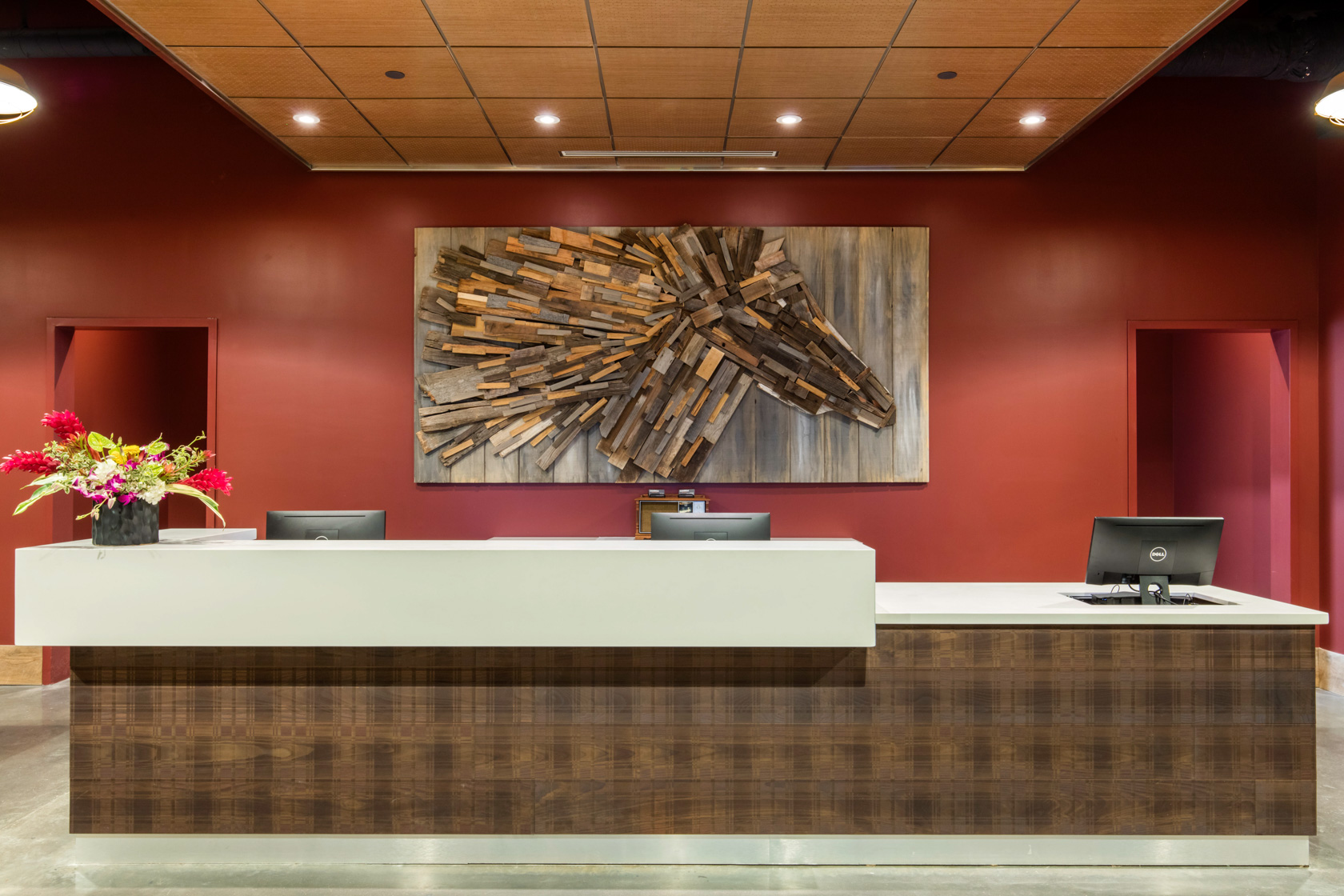 gallery Reception of a hotel with features as a red wall, elegant big paint and three desktops at nighttime