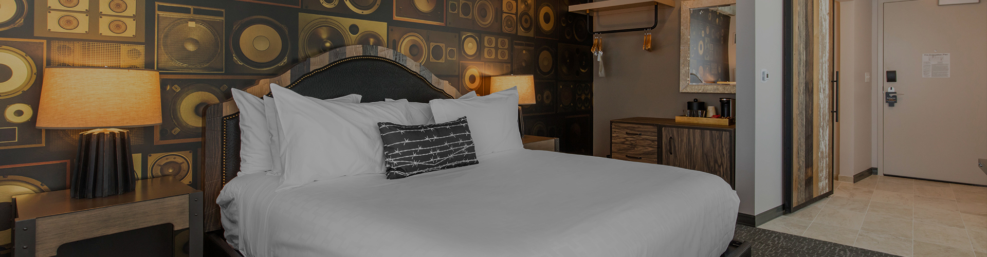 Closeup view of modish hotel room during the night with features as, radio style wall, two nightstands, lamps