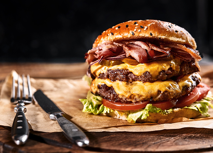 provocative double patty burger with bacon, double cheese, lettuce and tomato