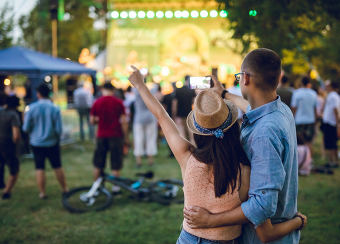 Backs of a guy and a lady taking a selfie in a outdoors event