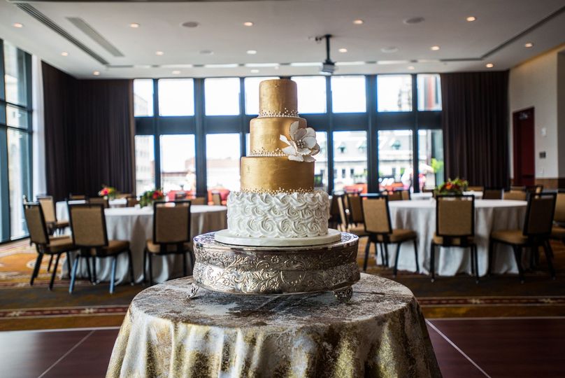 view of a three tier cake and tables in a events room of a hotel