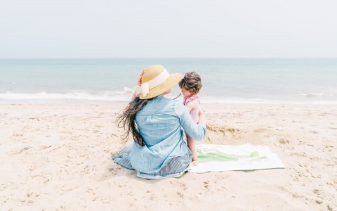 a woman with a beach hat holding her daughter