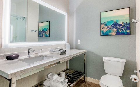 a bathroom with white towels and a picture on the wall