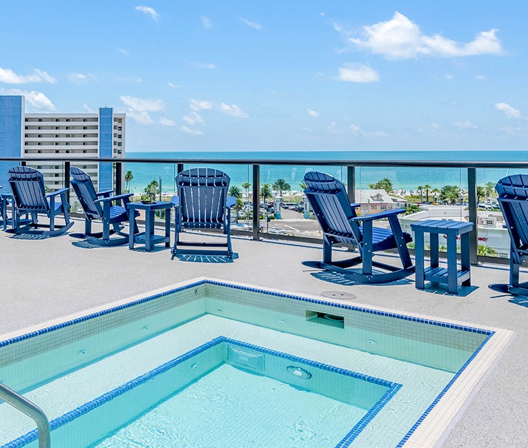 a rooftop pool with blue chairs