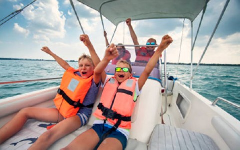 family having fun on a boat with life jackets on