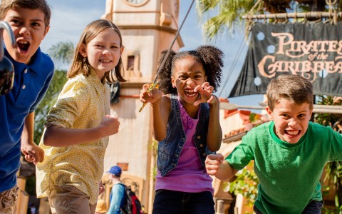 children posing in front of pirates of caribbean sign