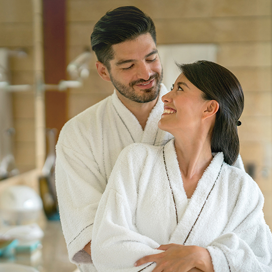 couple in robes smiling at each other