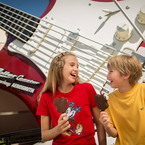 kids smiling with mickey ice cream bar and massive guitar behind them