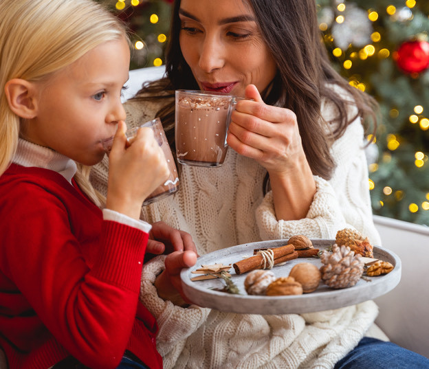 mom and girl drinking hot chocolate in christmas