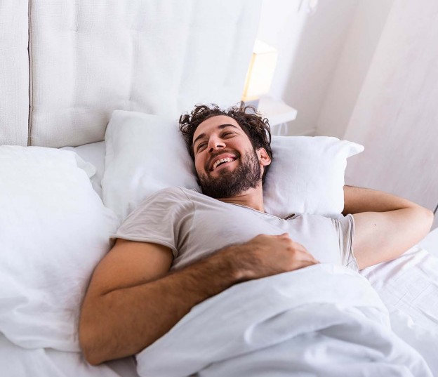man laying in a hotel bed 