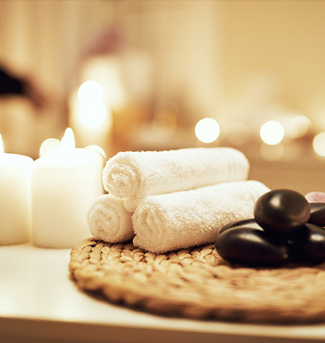 spa set up with three towels, candles and rocks