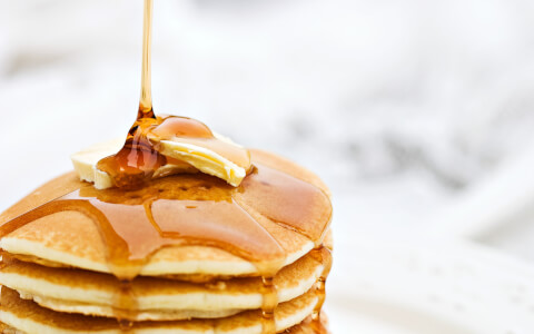 close up tower of pancakes with maple