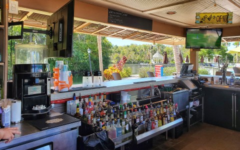 inside view of a bar near to the beach and two small tv's  on the corners 