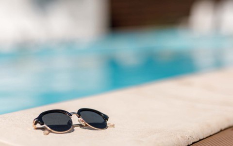 closeup view of a sunglasses in the swimming pool border 