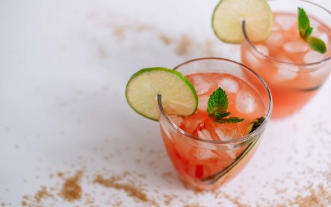 above image of two tropical cocktails with a sliced of lemon