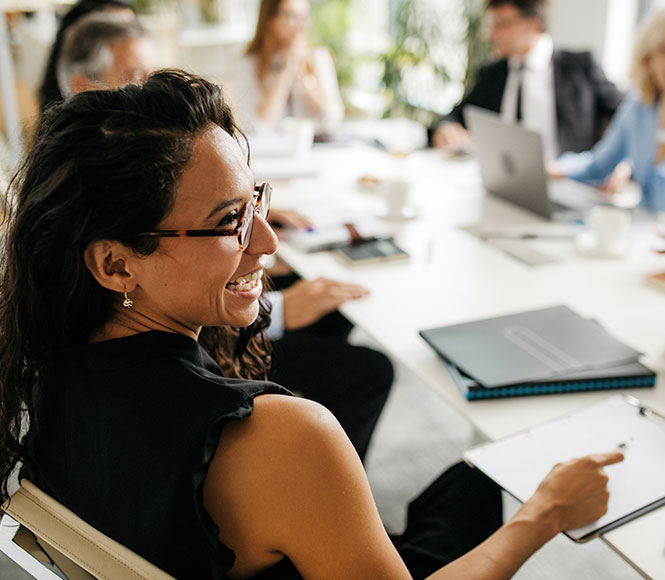 lady gathered in a meeting smiling and looking to the right side