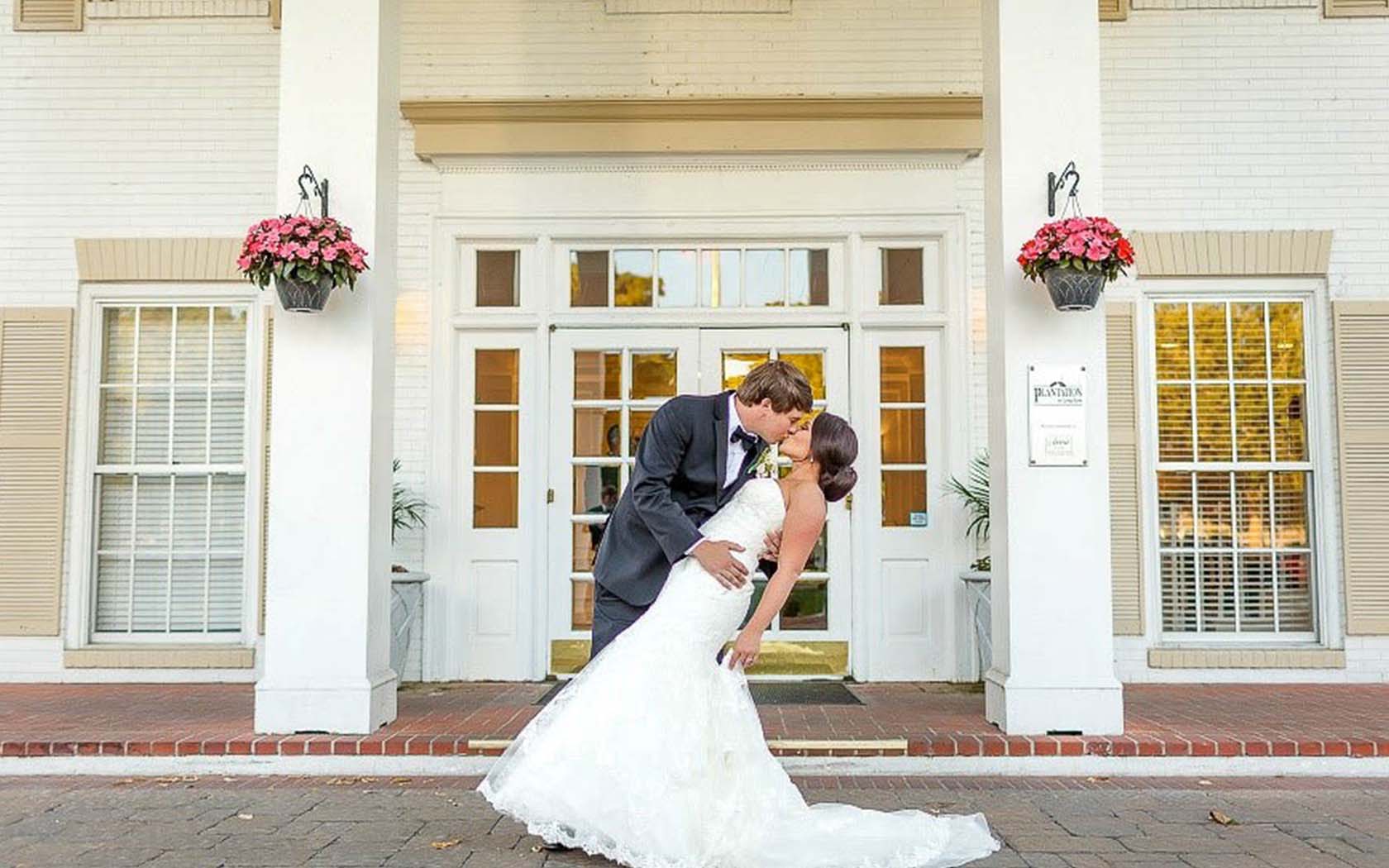 bride and groom kissing at the front of the house 