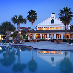 small image of an outdoor pool view of the property with a blue accents at sunset 