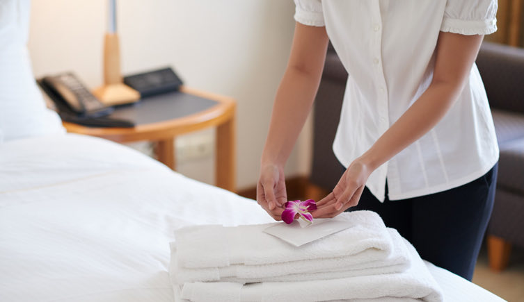 woman placing a flower on top of white towels
